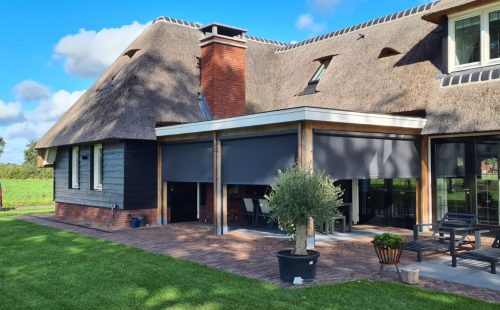Windvaste screens onder houten terrasoverkapping landelijke woning